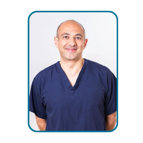 Ali Jahanfar smiling at camera in dark blue scrubs